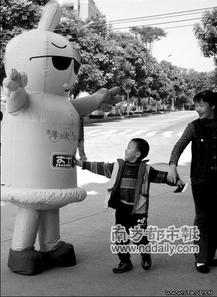 　　昨天,华农校园内,志愿者扮成避孕套宣传预防艾滋病激起了小朋友的好奇心。实习生冯炼娴本报记者张骏摄